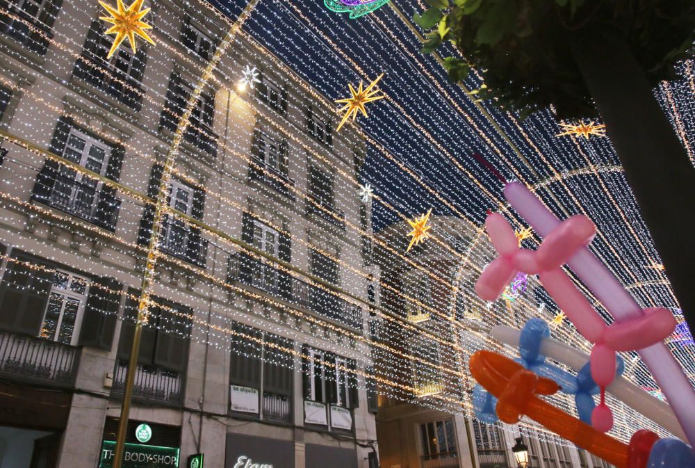 La principal calle del centro de Málaga ya luce los motivos carnavalescos, máscaras y antifaces, con motivo de la Fiesta del Invierno Cálido de la ciudad