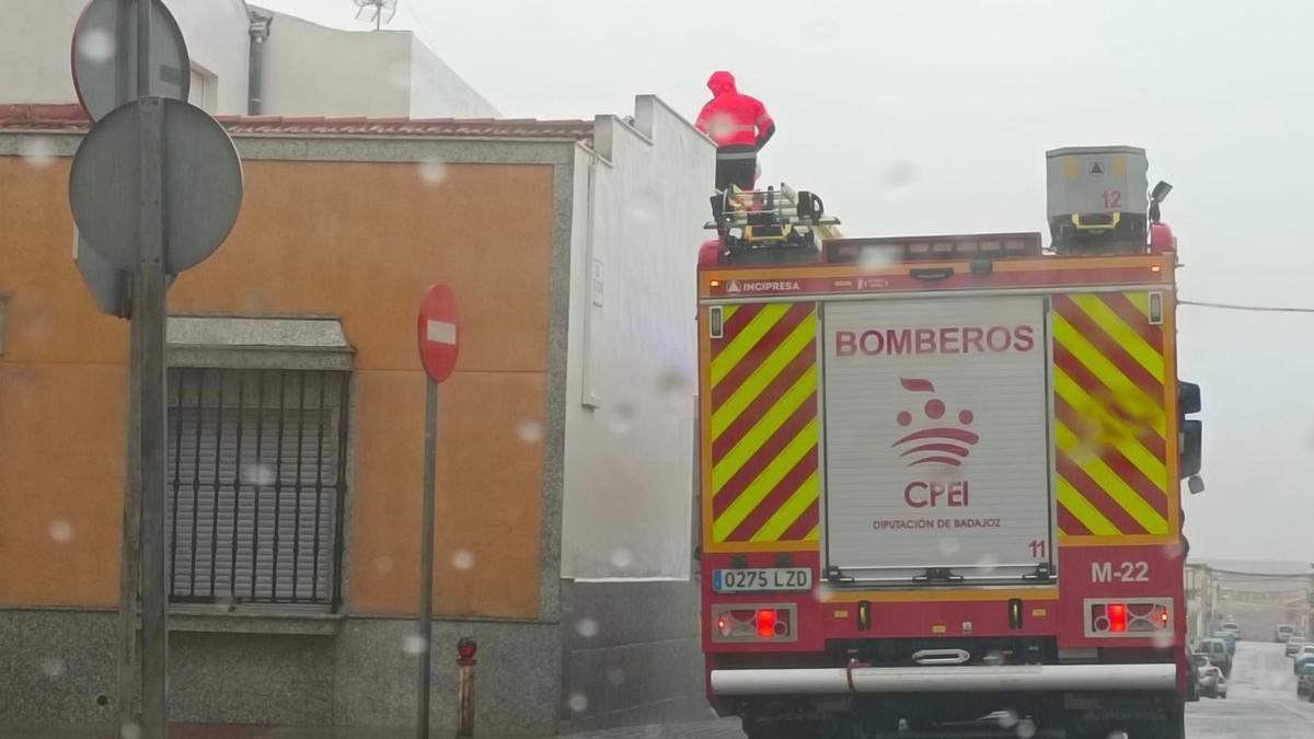 Fotogalería | La borrasca Aline azota Extremadura con lluvia intensa y fuertes vientos: Bomberos atendiendo una cubierta en la calle Federico García Lorca, en Almendralejo