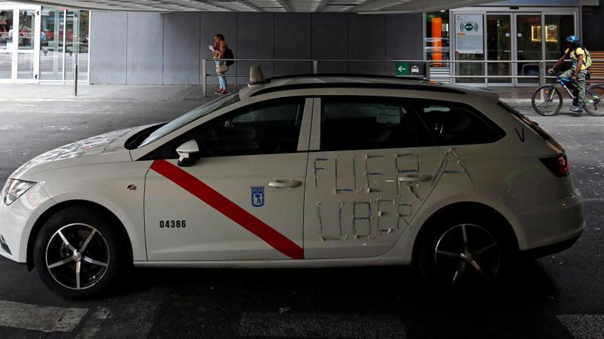 Un taxi en Madrid con pintadas contra Uber.