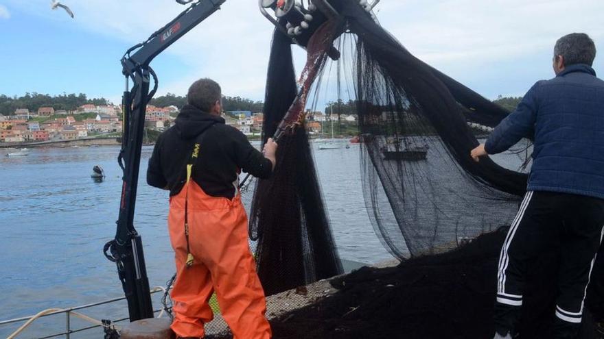 Marineros pertrechan un barco de cerco en A Illa, Vigo.