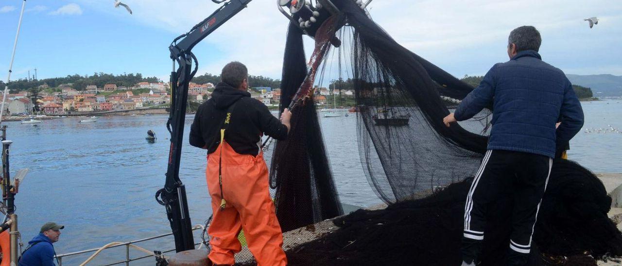 Marineros pertrechan un barco de cerco en A Illa, Vigo.