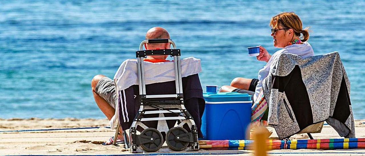 Una pareja toma
el sol en la playa
de Levante de
Benidorm. david revenga |