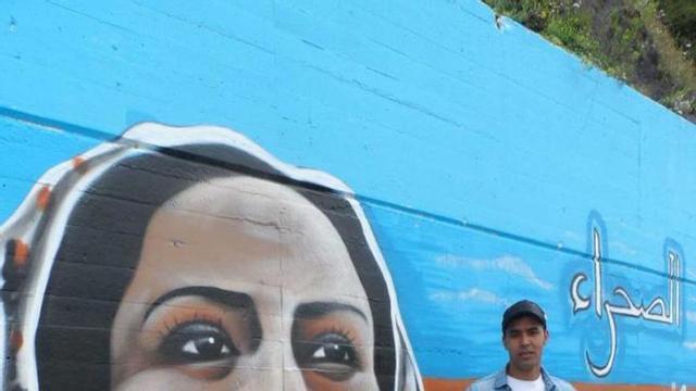 Aby Athman, junto a un grafiti saharaui en el paseo marítimo de Candás.