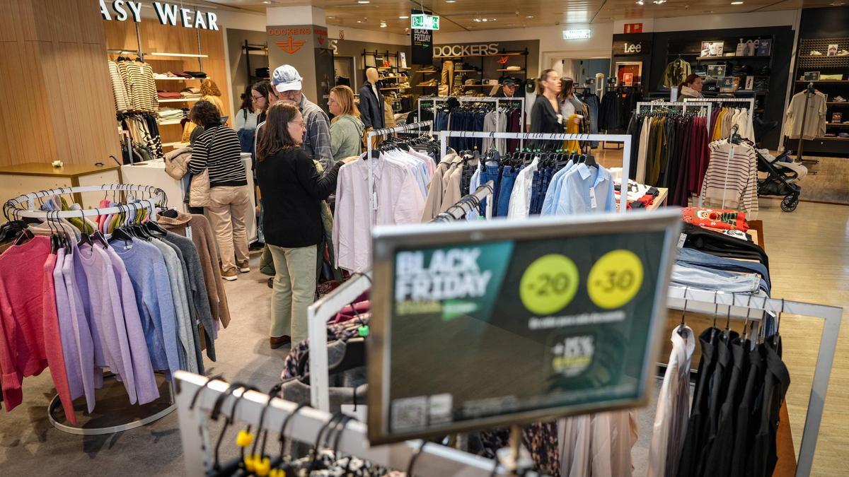Varios clientes esperan para pagar sus compras con descuentos por el Black Friday en El Corte Inglés de Badajoz.