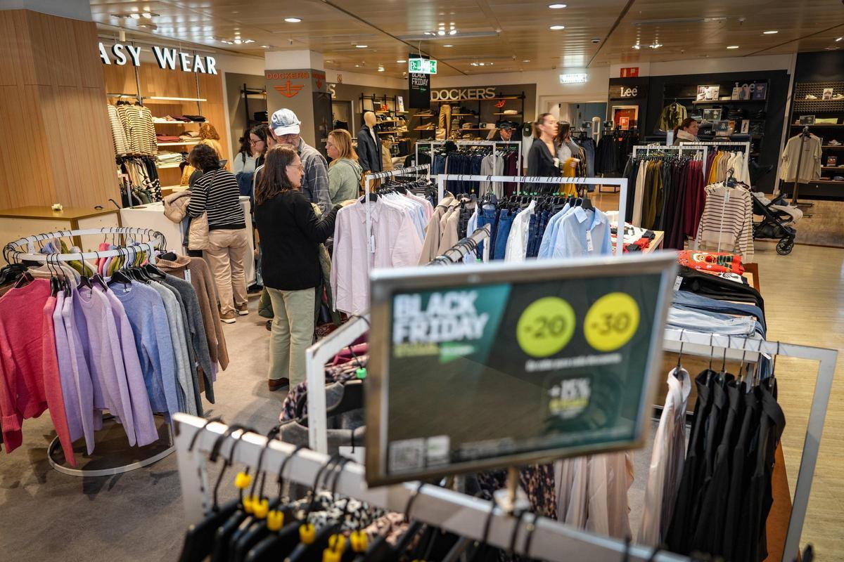 Varios clientes esperan para pagar sus compras con descuentos por el Black Friday en El Corte Inglés de Badajoz.
