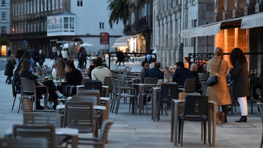 Clientes y mesas vacías en una terraza de A Coruña.