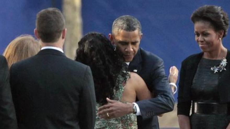 La primera dama estadounidense, Michelle Obama (d), observa como el presidente de EEUU, Barack Obama (d), saluda a los familiares de las víctimas del 11-S.