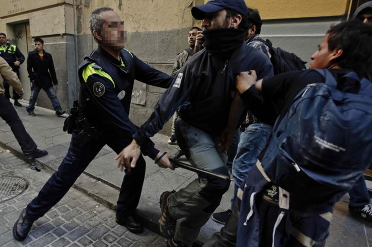 Un policia desallotja un grup de piquets que ha protagonitzat incidents a la plaça del Callao, al centre de Madrid.