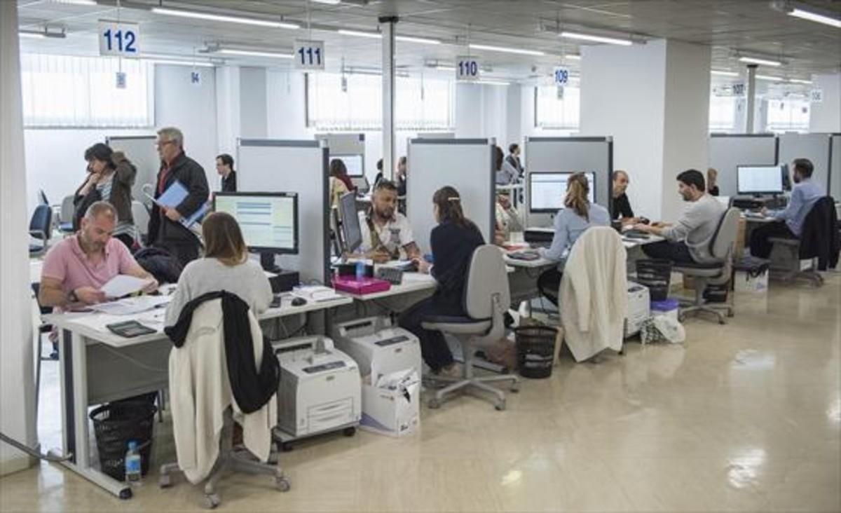 Ciudadanos gestionan la declaración de renta en la Agencia Tributaria, en Barcelona.