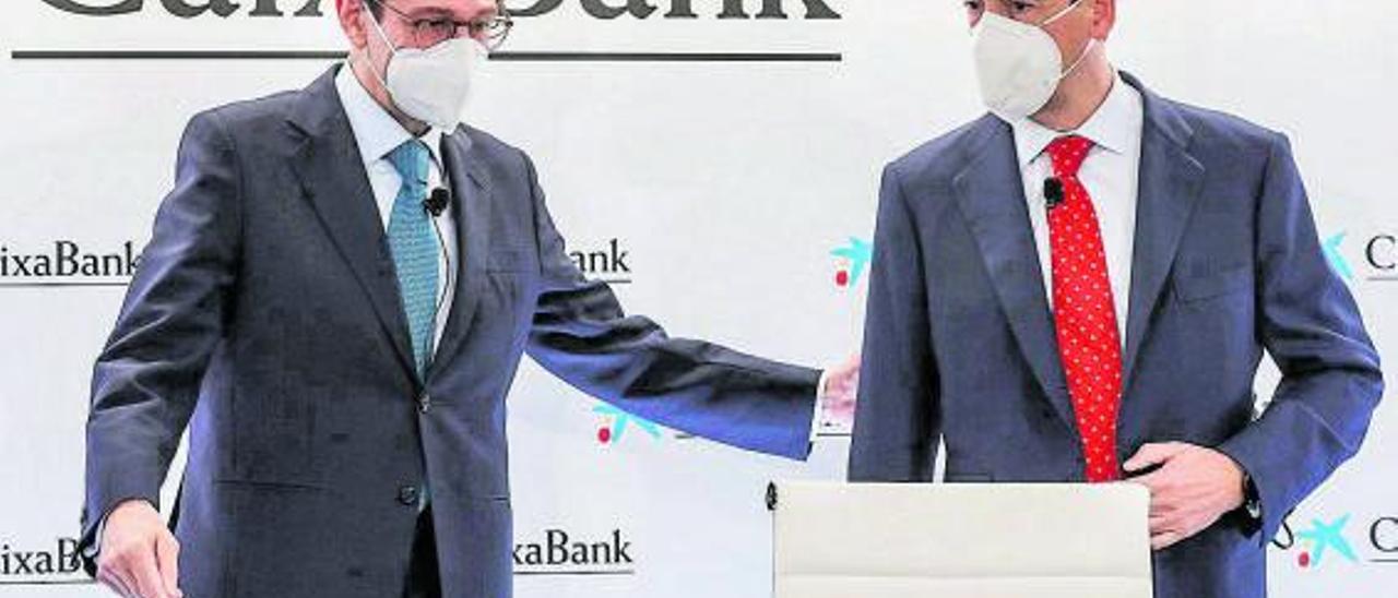 El presidente de CaixaBank, José Ignacio Goirigolzarri (izquierda), y el consejero delegado de la entidad, Gonzalo Gortázar, ayer a 
su llegada a la rueda de prensa celebrada en Valencia.  | | ROBER SOLSONA