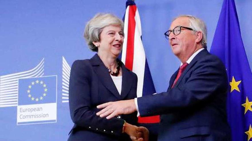 May y el presidente de la CE, Jean-Claude Juncker. // Reuters