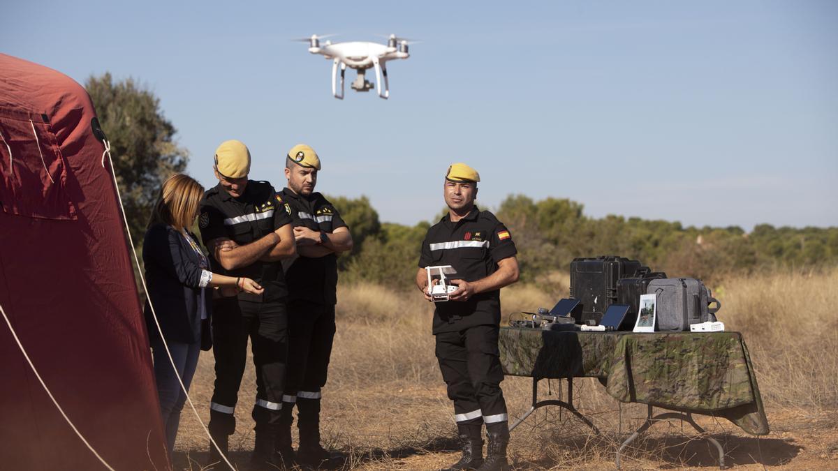 La delegada del Gobierno, Pilar Bernabé, a la izquierda, mientras un miembro de la UME maneja un dron.