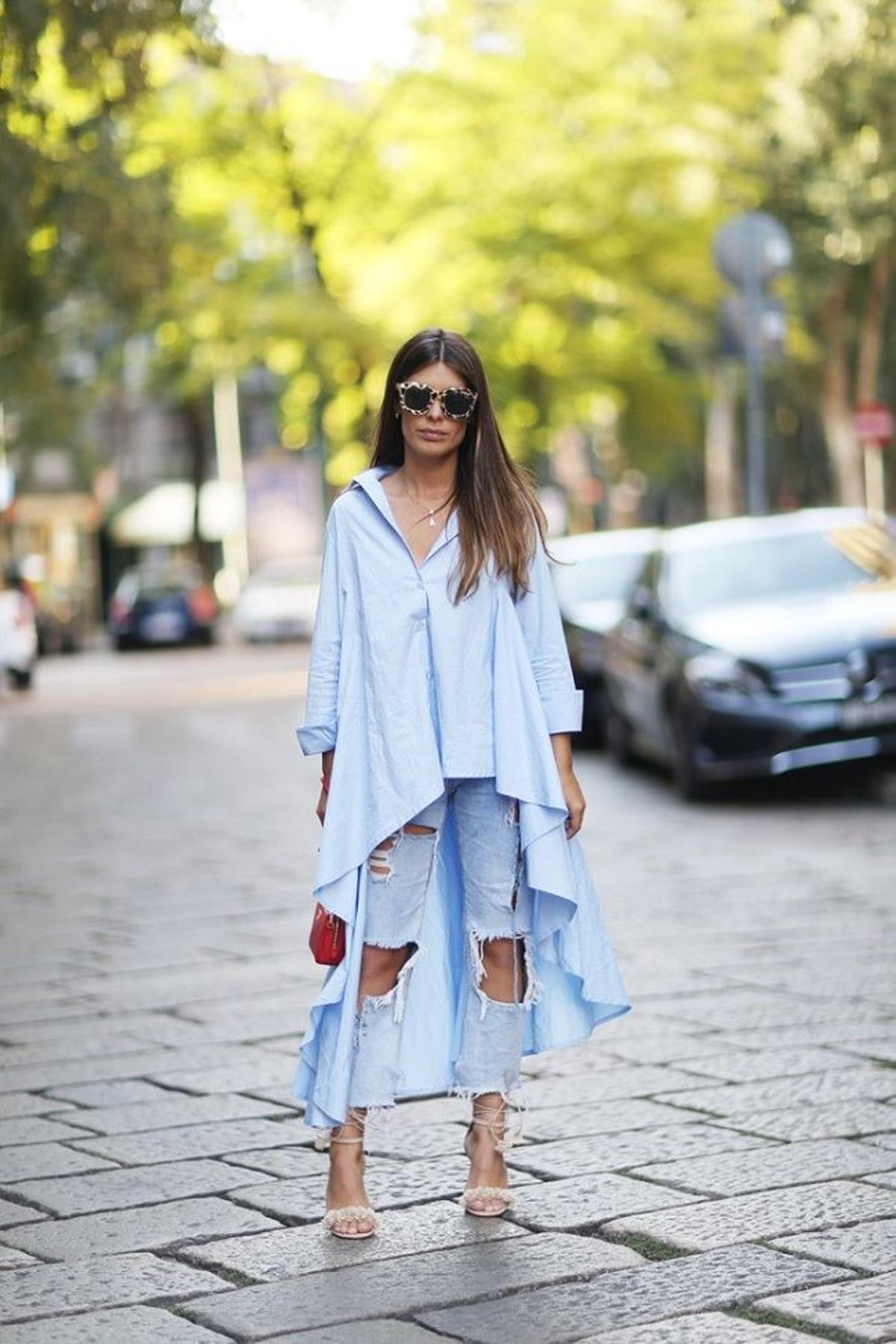 El look de Dulceida con camisa ancha asimétrica y pantalones vaqueros en la Semana de la Moda de Milán