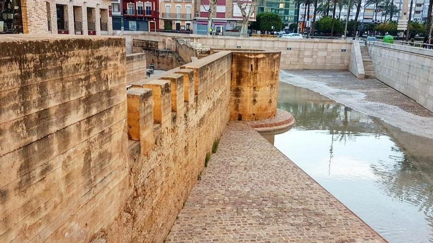 La lamina de agua que recrea el antiguo paso del Xúquer junto a la muralla árabe.