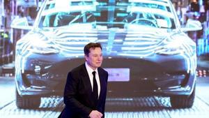 FILE PHOTO: Tesla Inc CEO Elon Musk walks next to a screen showing an image of Tesla Model 3 car during an opening ceremony for Tesla China-made Model Y program in Shanghai