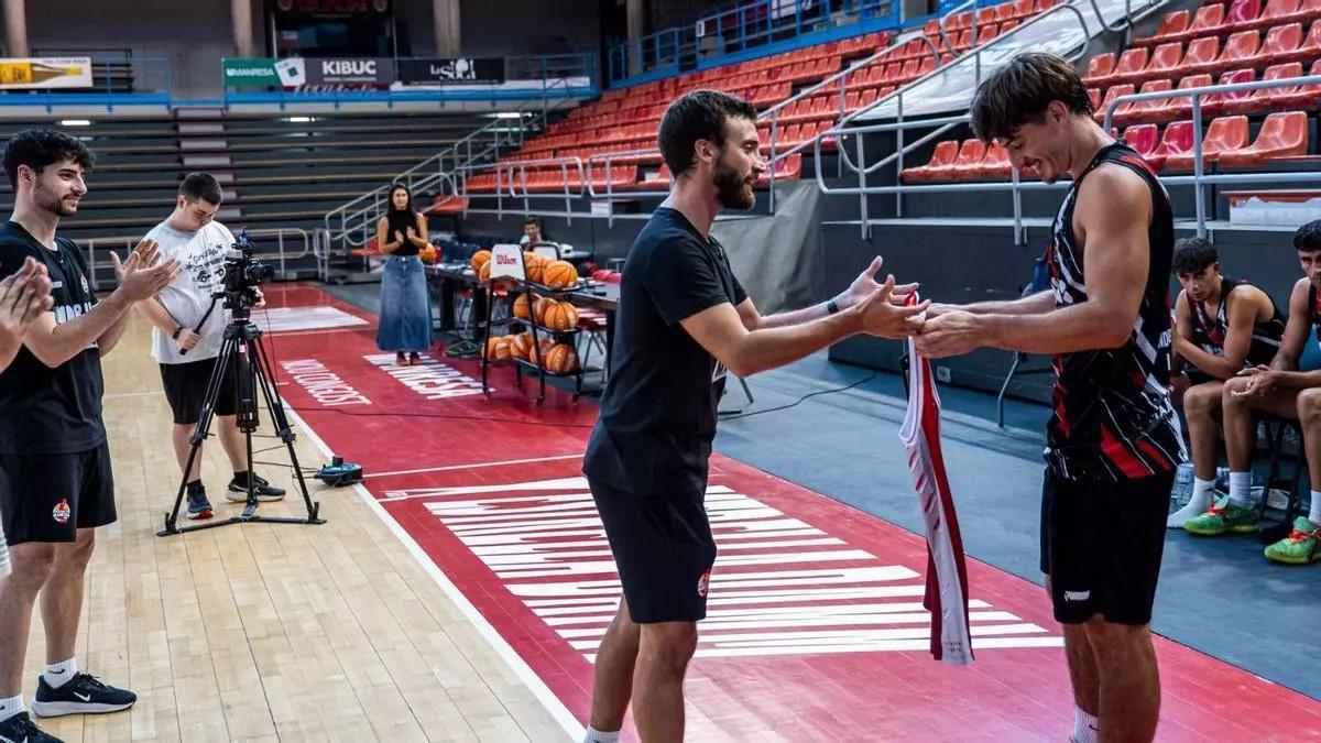 Carlos Flores entrega la camiseta a Raurich tras ganarse la plaza para entrenar con el primer equipo