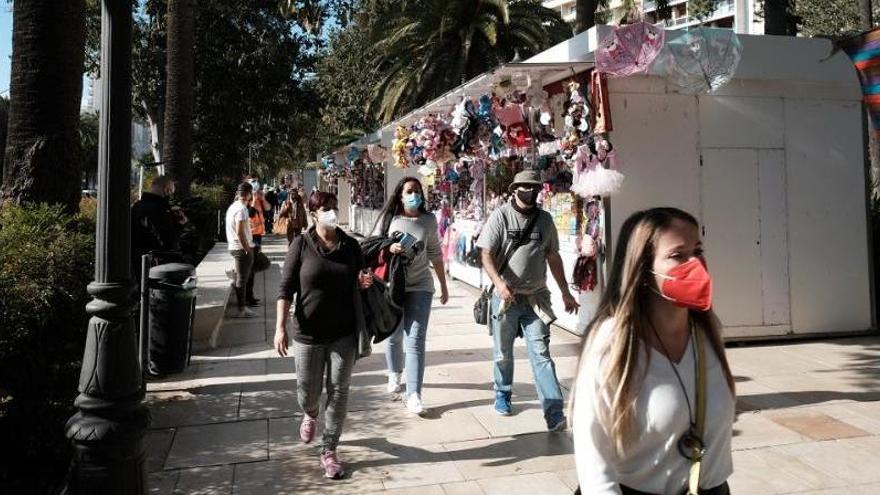 Varias personas pasean por el mercado navideño del Parque.