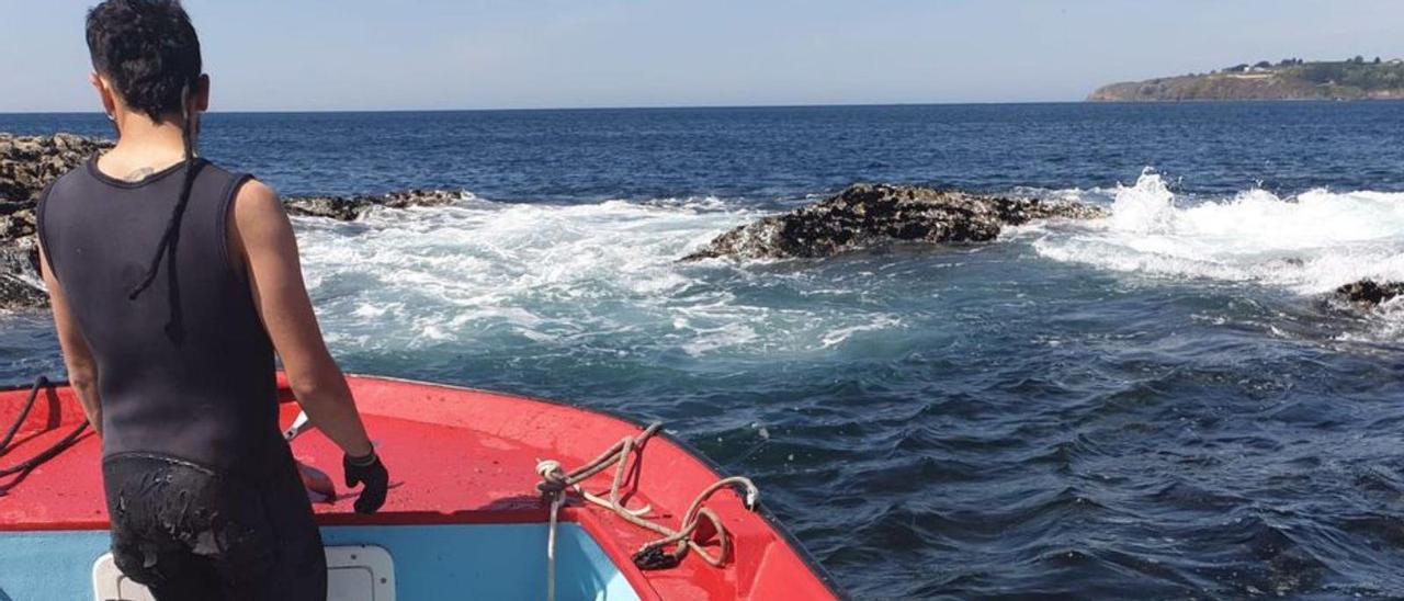 Un bateeiro acude a las rocas para obtener mejilla.   | // FARO