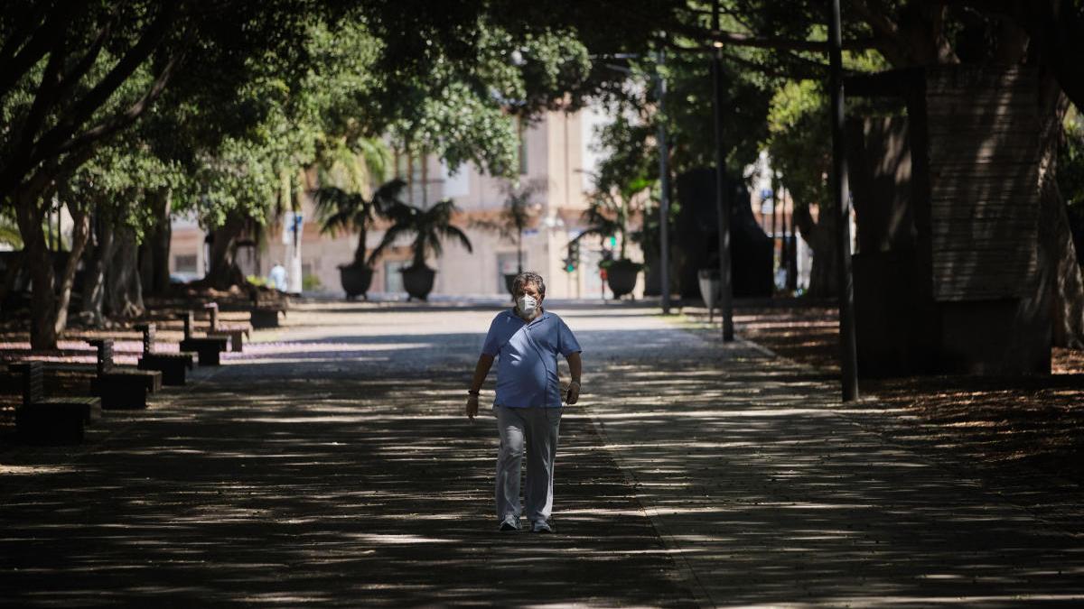 Una mujer con mascarilla camina por el parque García Sanabria.