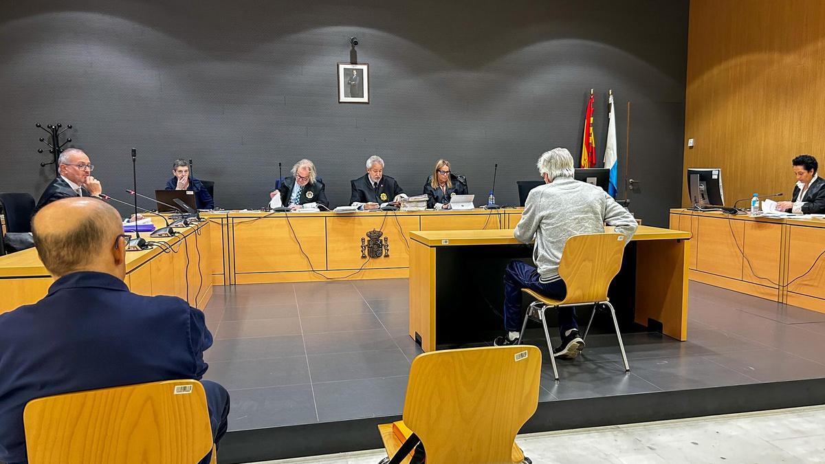 Víctor T. R. , uno de los acusados, sentado al banquillo en el juicio bajo la atenta mirada de Óscar D. L.