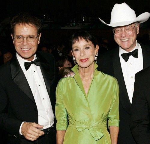 El cantante británico Cliff Richard (iz) con  Geraldine Chaplin (C) y Larry Hagman, en una gala de caridad en Mannheim (2004)