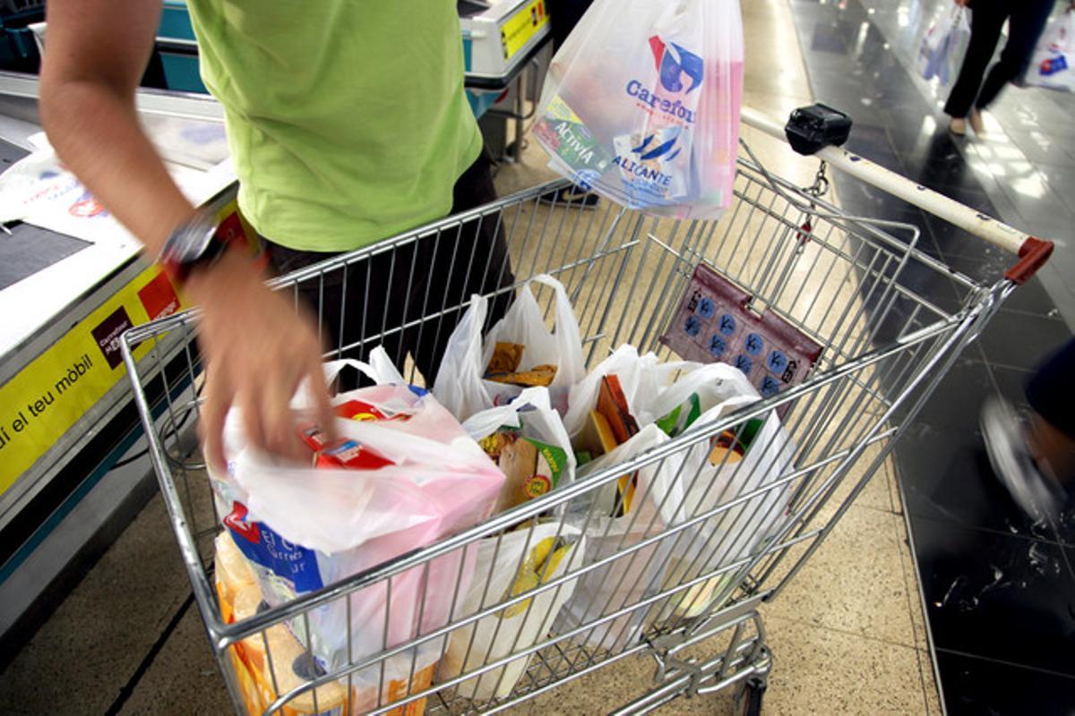 Un home, amb el carro de la compra, en un supermercat. Un home, amb el carro de la compra, en un supermercat.