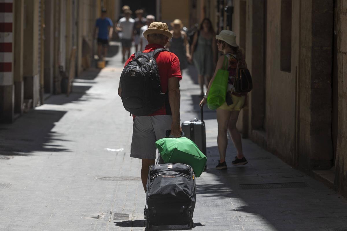 Turistas sufriendo los rigores del calor por una calle del Carmen