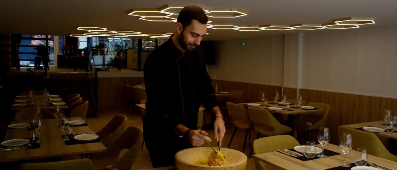 Adrián Santórum preparando espagueti sobre rueda de queso.