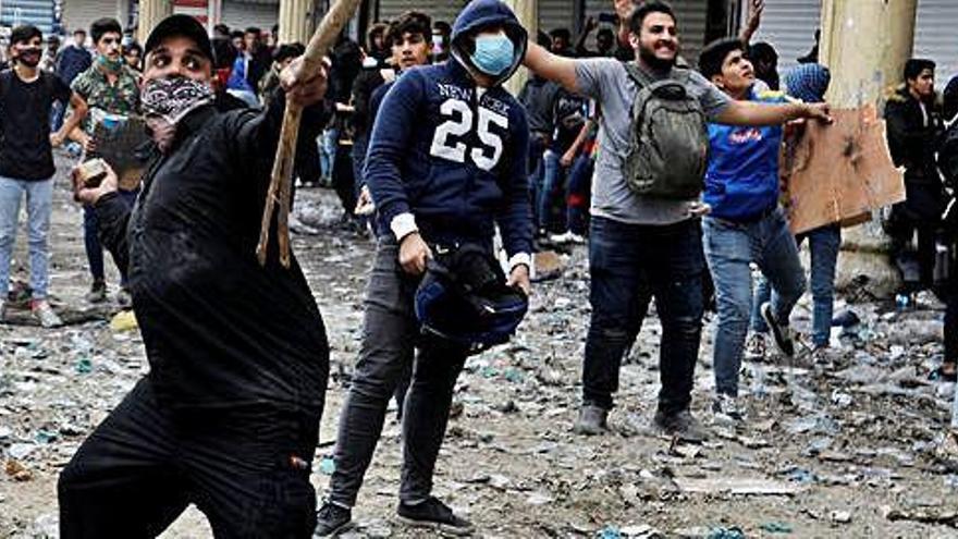 Manifestants llancen pedres a la policia, a Bagdad