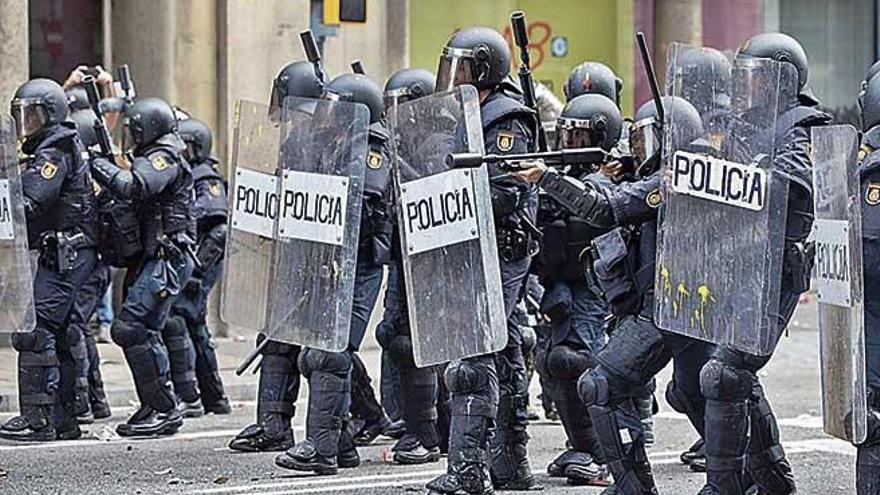 Agentes de la PolicÃ­a Nacional alcanzados por balas de pintura durante una de las manifestaciones.