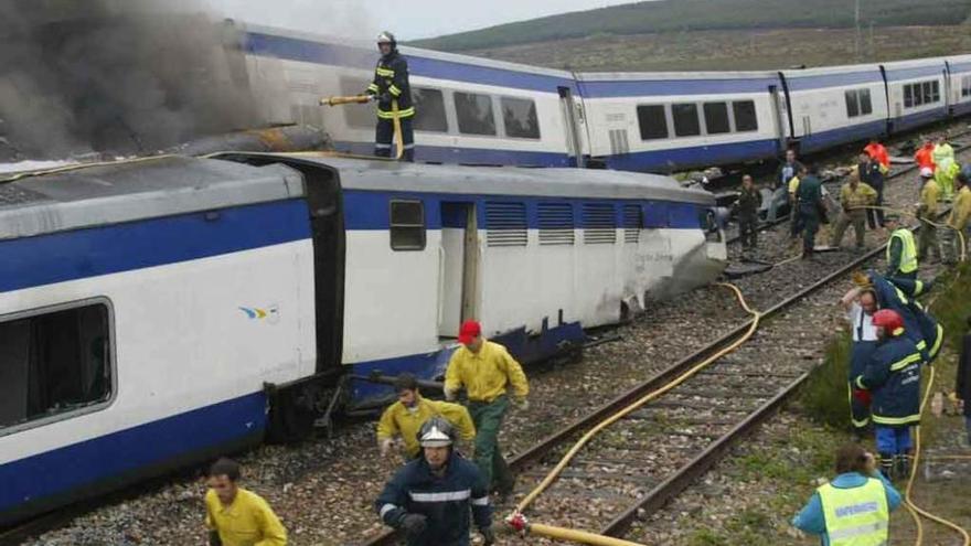 Operarios intervienen para sofocar el fuego que se originó al colisionar los trenes en 2004.