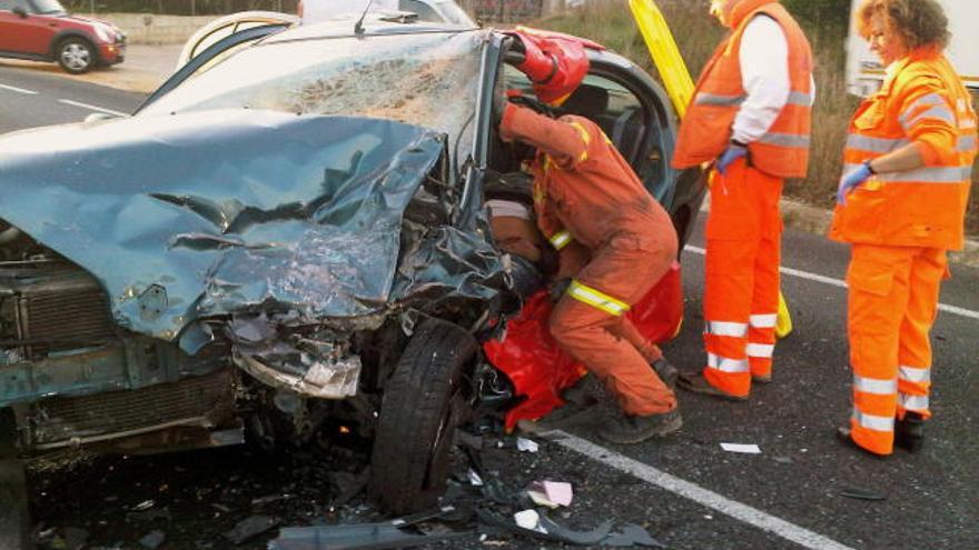 Los bomberos trabajan en el rescate de una de las víctimas en el accidente.