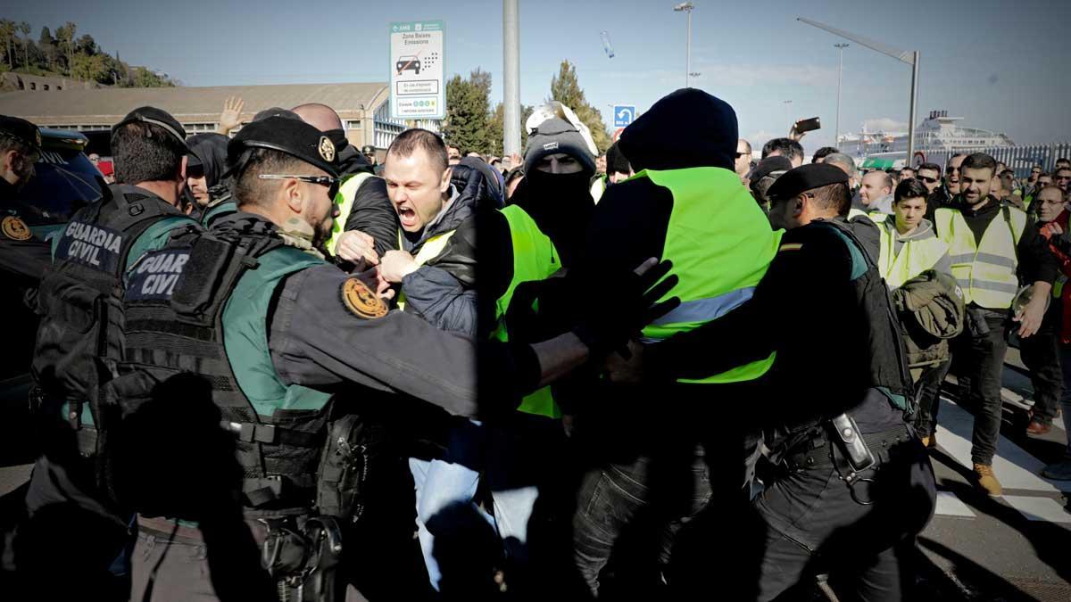 Los taxistas de Barcelona saltan un cordón policial de la Guardia Civil para entrar en el puerto.