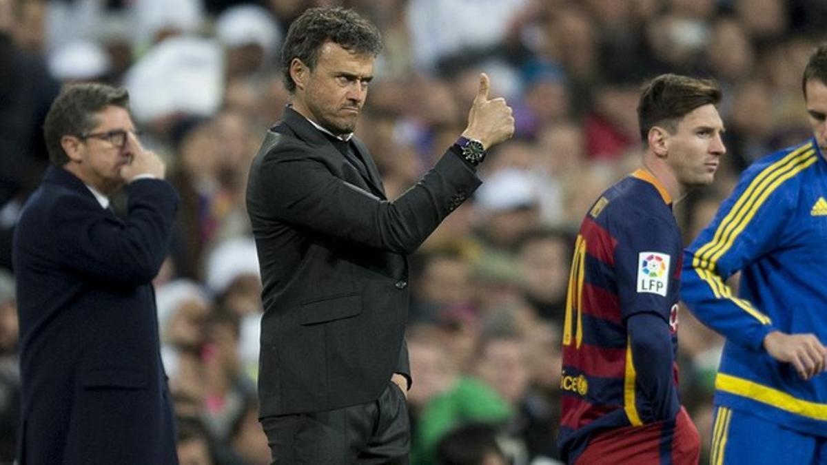 Luis Enrique felicita a un jugador instantes antes de que entre Messi al césped del Bernabéu.