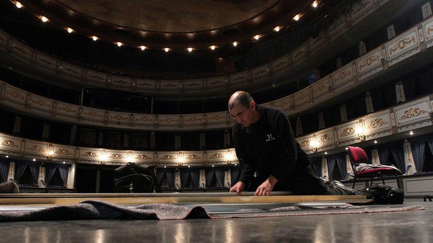Un operario trabaja sobre el escenario del Teatro Cervantes.