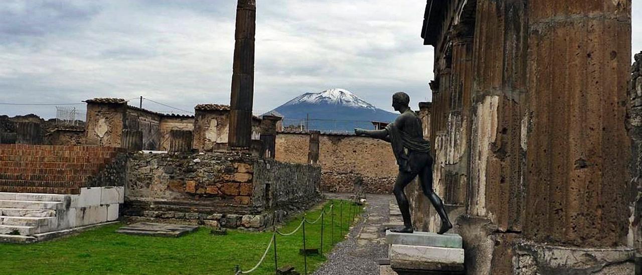 Restos de la ciudad de Pompeya destruida por el Vesubio, que se observa en lo alto del fondo. |