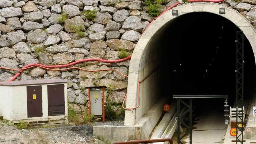 La boca de uno de los túneles en Los Pontones (Lena), con un poste de la catenaria en primer término.