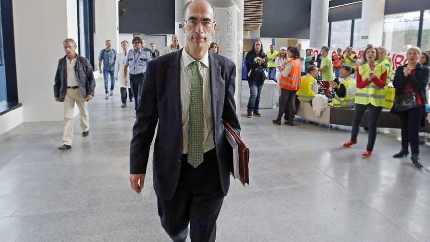 El conselleiro atraviesa el hall donde están acampados los celadores tras la reunión con los jefes.