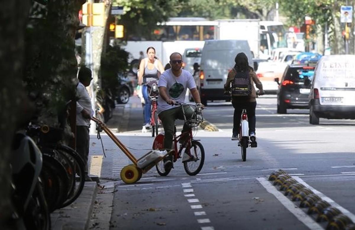 Un ciclista sortea a un transportista que no le ha visto venir de bajada, en la calle de Girona entre Aragó y València, el viernes.