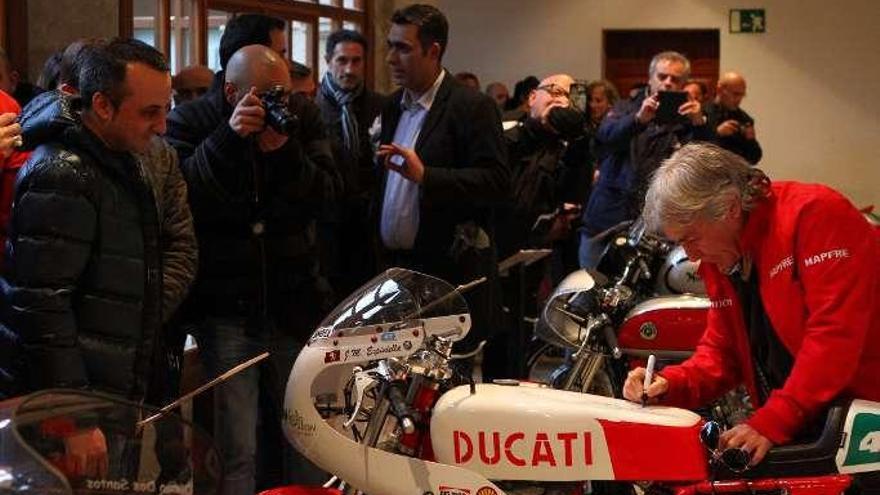 El deportista zamorano firma un autógrafo sobre una Ducati.