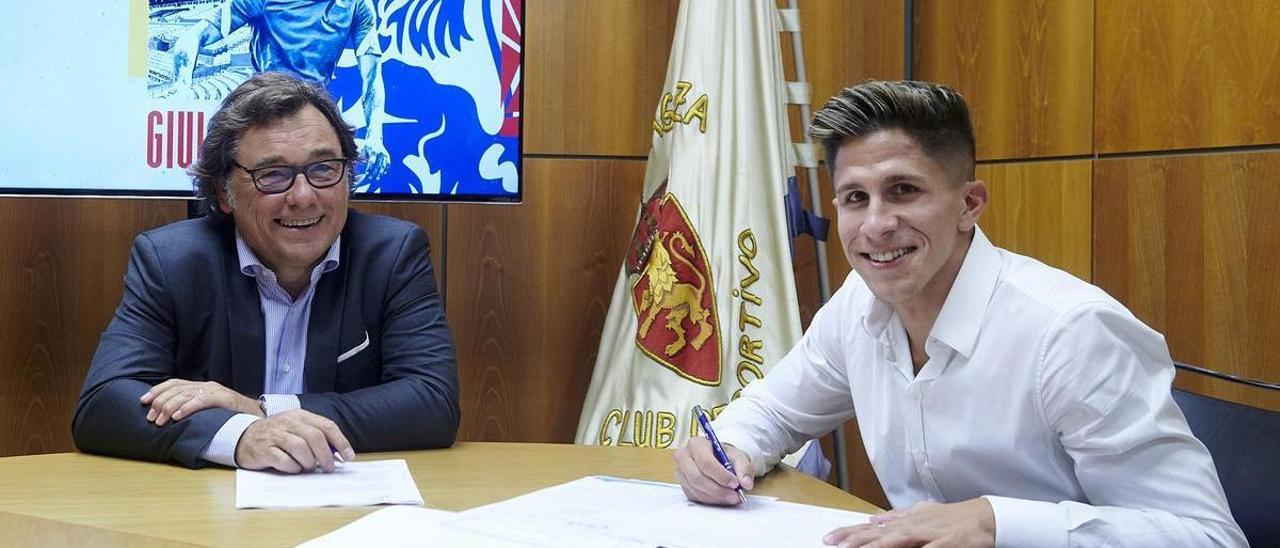 Giuliano Simeone, durante la firma del contrato junto con el director general del Real Zaragoza, Raúl Sanllehí.