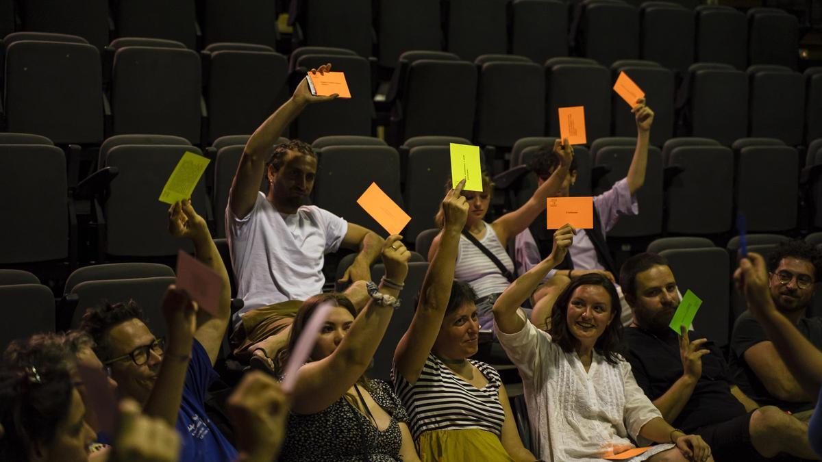 El público vota con cartulinas a mano alzada durante el espectáculo.