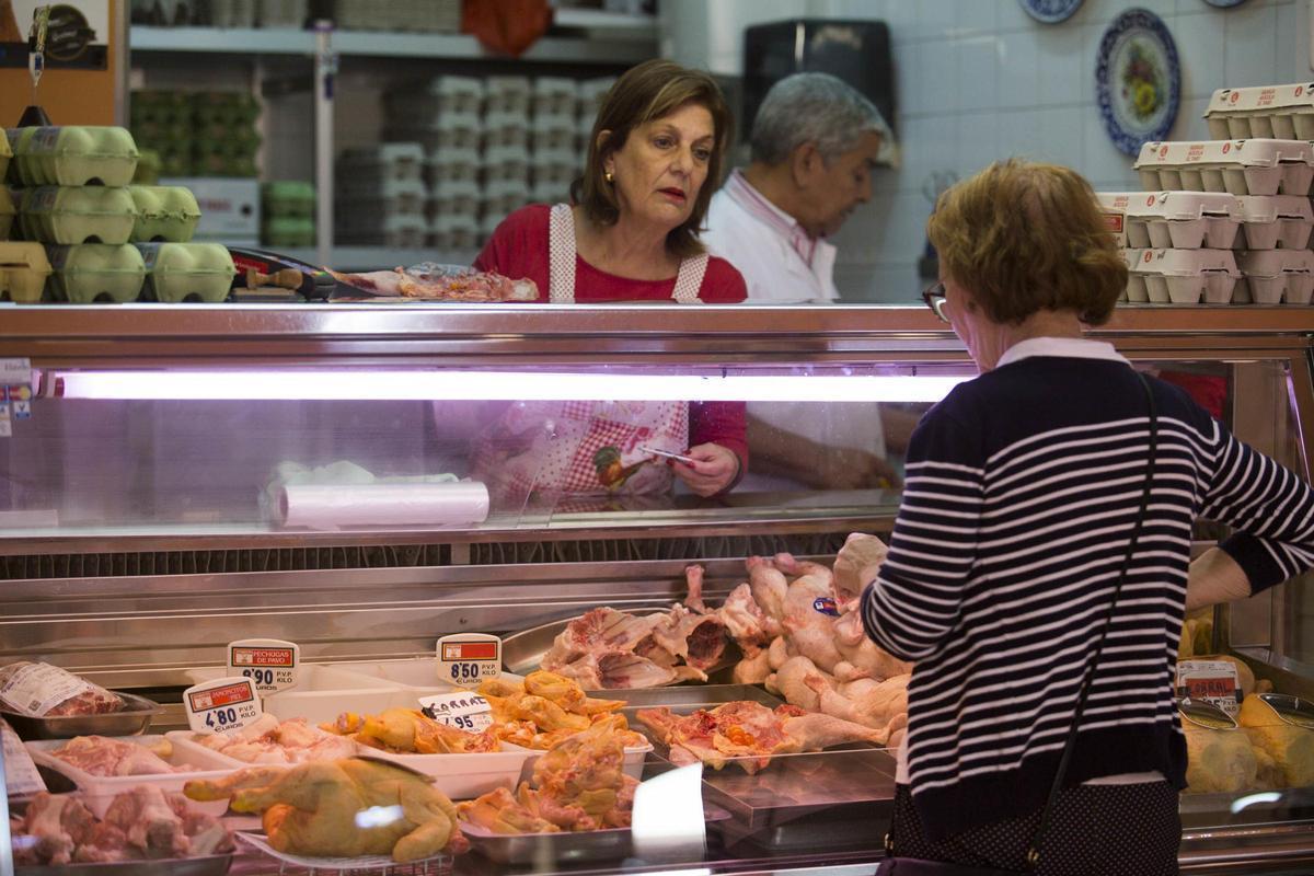 Una mujer compra en un puesto de un mercado de Canarias.