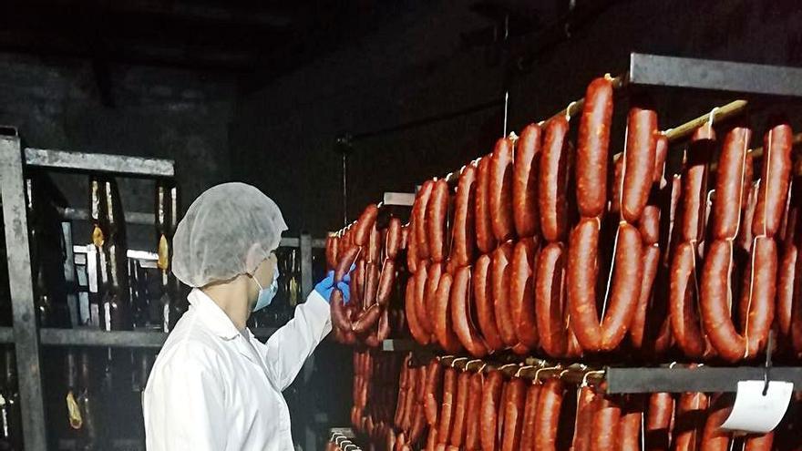 En la imagen superior, un operario, en la sala de ahumado de Maybe. Sobre estas  líneas, Iker García; y  a la izquierda, el desgranado de las fabas y una de las máquinas para controlar la calidad de los embutidos.