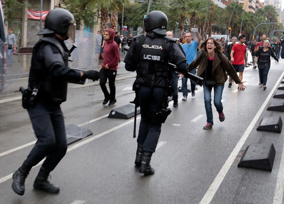 Una mujer se enfrenta a dos agentes de la Policía Nacional.