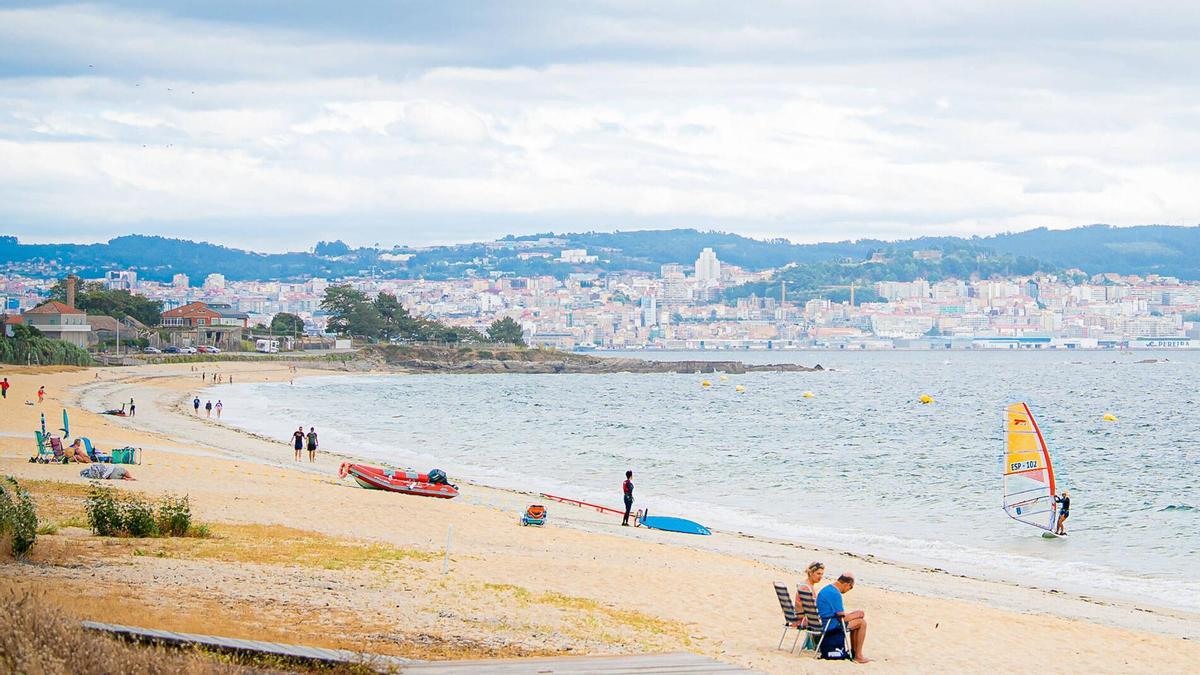 La playa canguesa de Rodeira, este lunes, con bañistas y usuarios practicando windsurf.