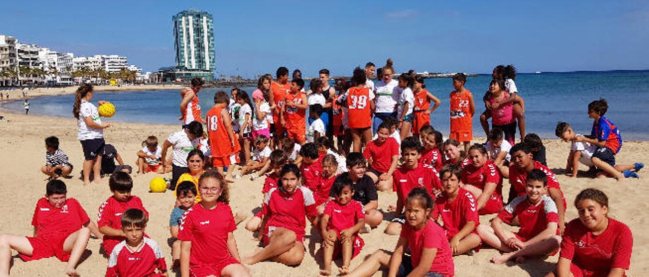 Integrantes del Club Baloncesto Conejero (al fondo) y el Club Balonmano San José Obrero (sentados), ayer, en la playa de El Reducto durante la protesta.