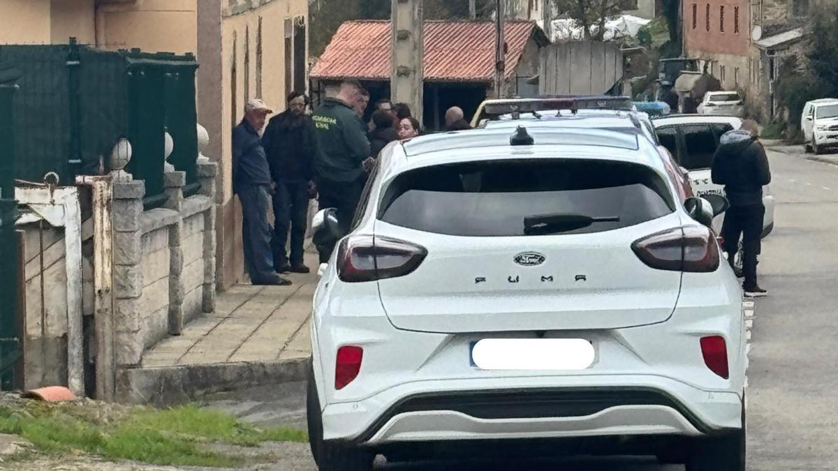 Tomasín, de negro y con una prominente barba tras días echado al monte, rodeado de guardias civiles y efectivos de emergencia en el bar tienda de Obona