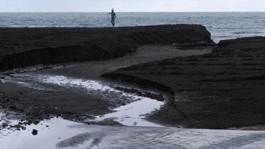 Imagen del estado de la playa de Melenara, ayer, tras las fuertes precipitaciones que cayeron en el municipio teldense. Al fondo, la estatua de Neptuno. i YAIZA SOCORRO