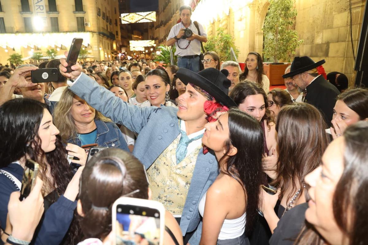 Funzo, escoltado por al Policía, se fotografía con fans al término del pregón